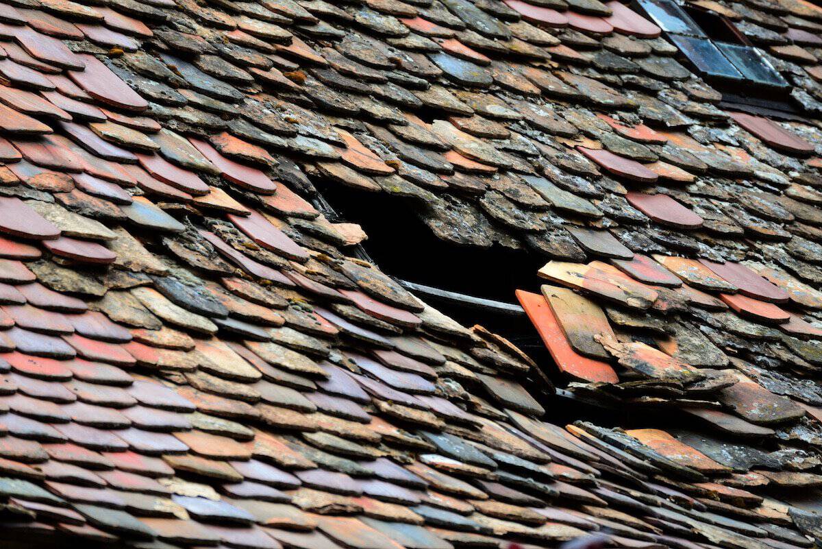 Understanding Roof Replacement Costs | A Damaged roof in bad need of a major repair.