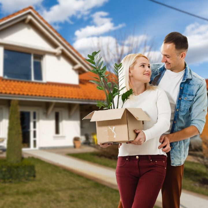 Home Selling Strategies | Couple hold a plant after selling their home.