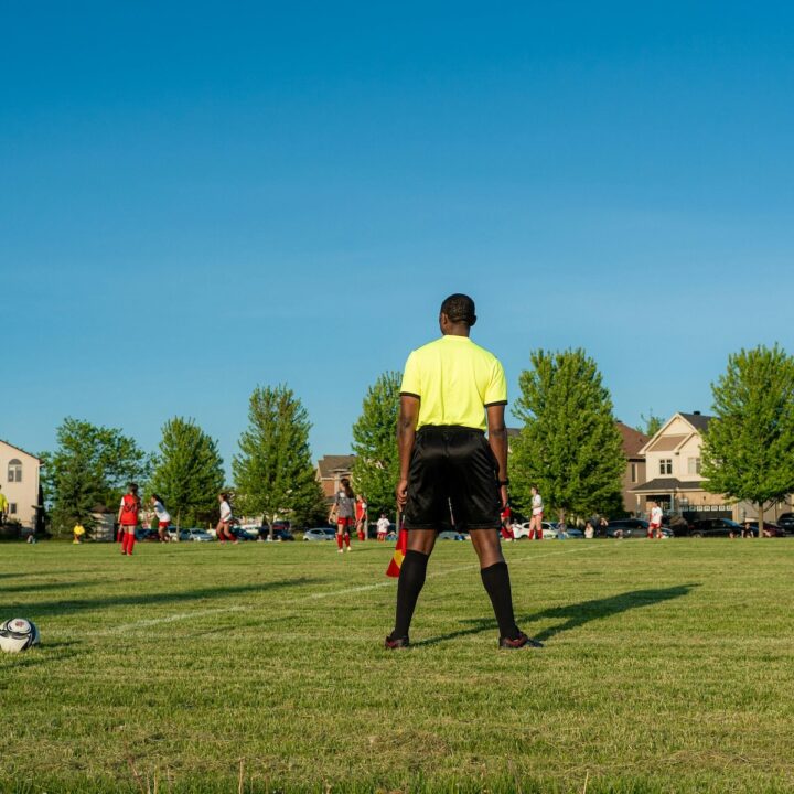Every Sports Parent Should Know | A girls soccer match with lines-man with a flag.