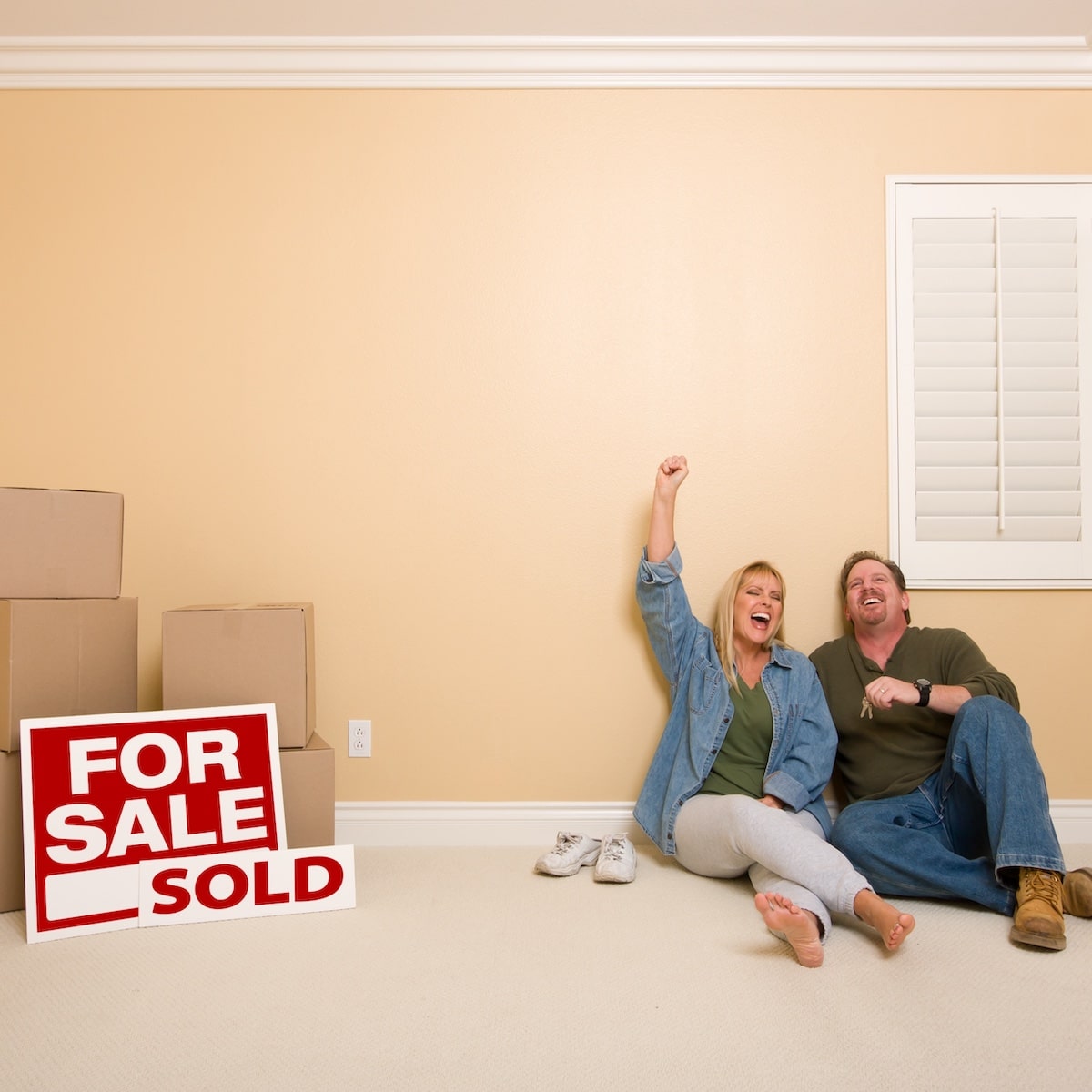 Home sold for cash | A couple celebrating the sale of their home.