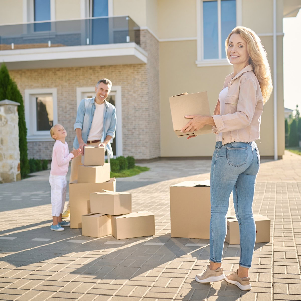 Quick home sale in Deerfield for fast job transfers | Family moving to a new house and carrying cardboard boxes.
