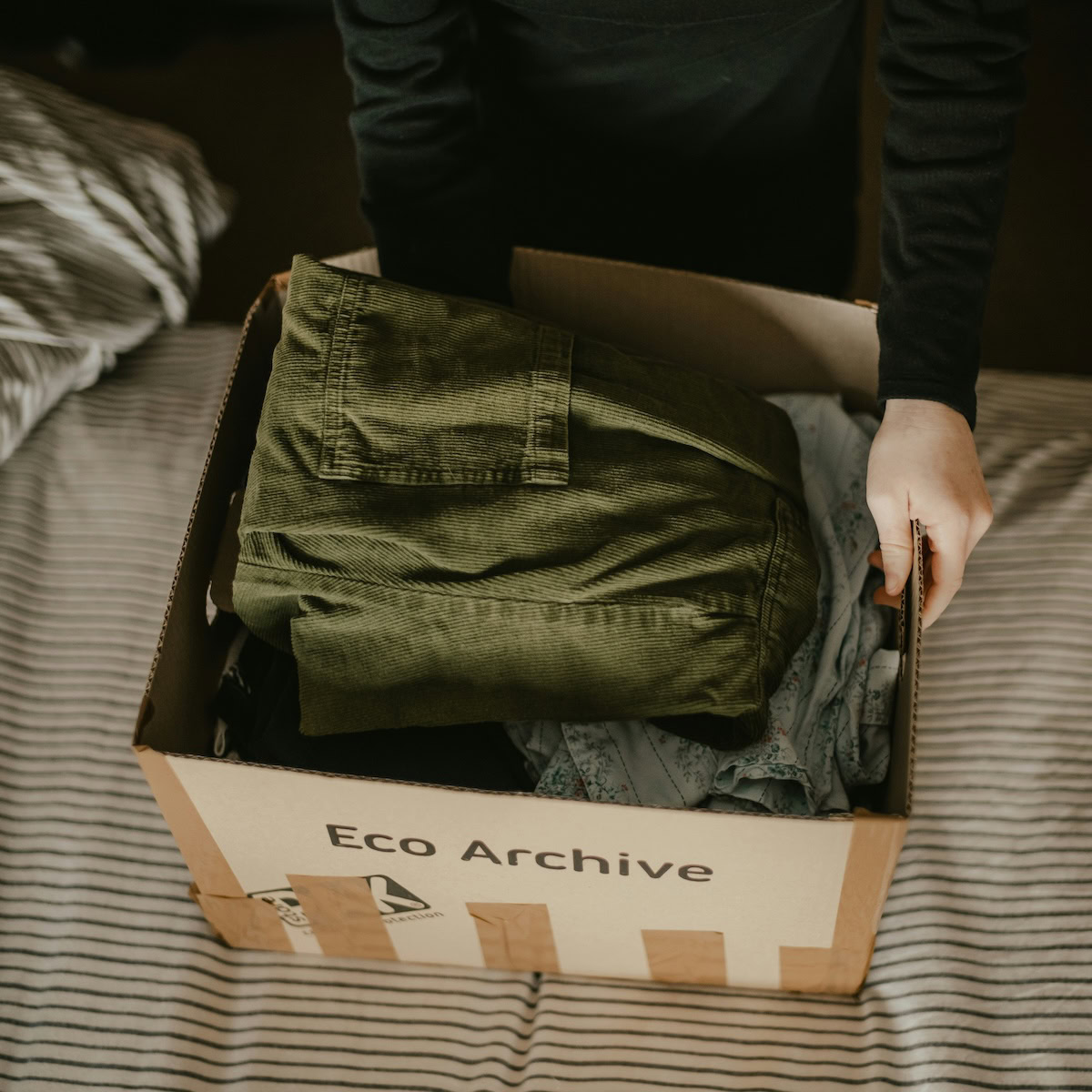 packing clothes to move home into a box.