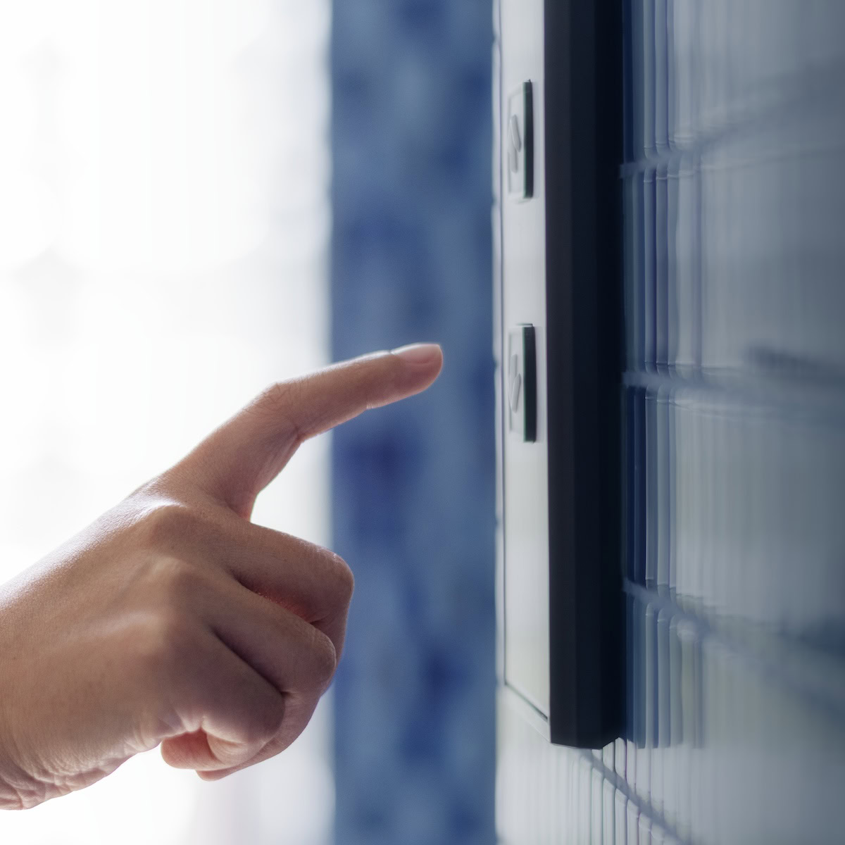Woman hand pressing security screen for door.