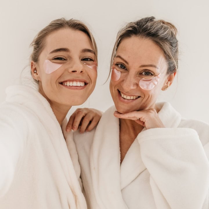 two women smiling with glowing skin.