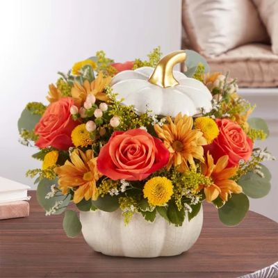 A plentiful mix of blooms gives our autumn arrangement an undeniable charm. Loosely gathered with pops of orange and yellow, it’s the perfect contrast to our modern-styled pumpkin. Featuring a white satin finish, crackle detail and rich golden accents, this harvest-inspired container is perfect for repurposing.