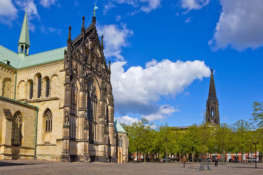 Historisches Stadtbild von Münster mit dem St.-Paulus-Dom und der Lambertikirche – entdecken Sie stilvolle Begegnungen mit Capsai Escort Münster vor beeindruckender Kulisse.