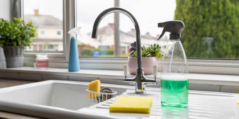 A selection of cleaning products on top of a kitchen sink