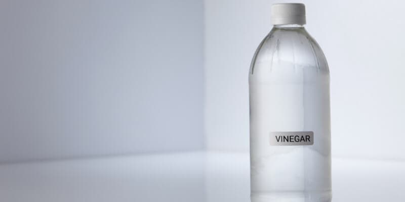Bottle of white vinegar on gray white background