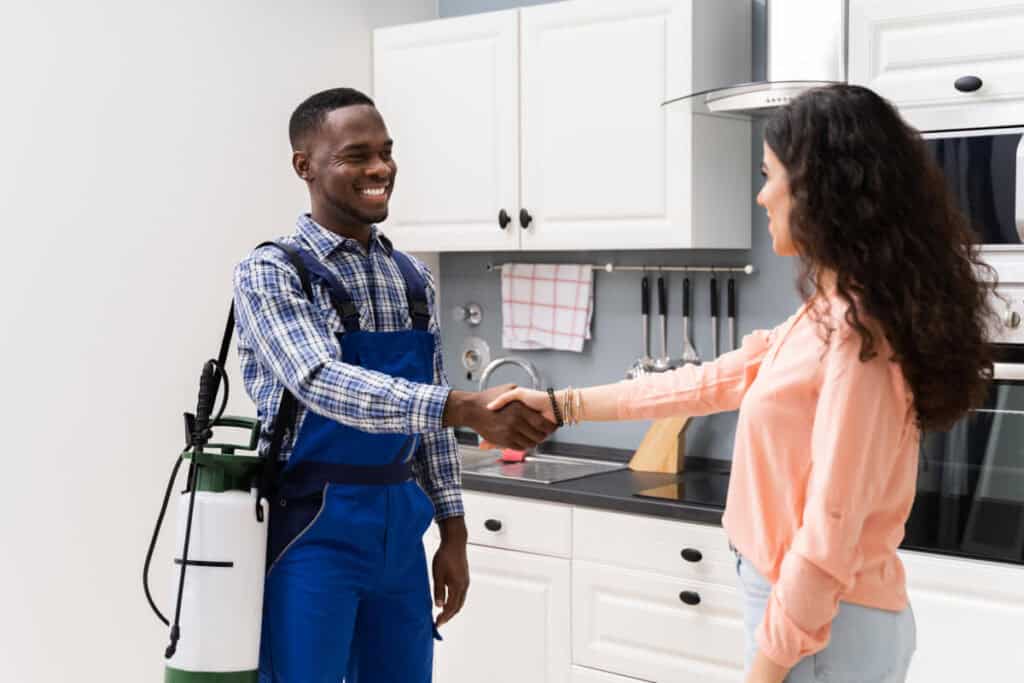 pest control worker shaking hands with client over a job well done in ant control for the house