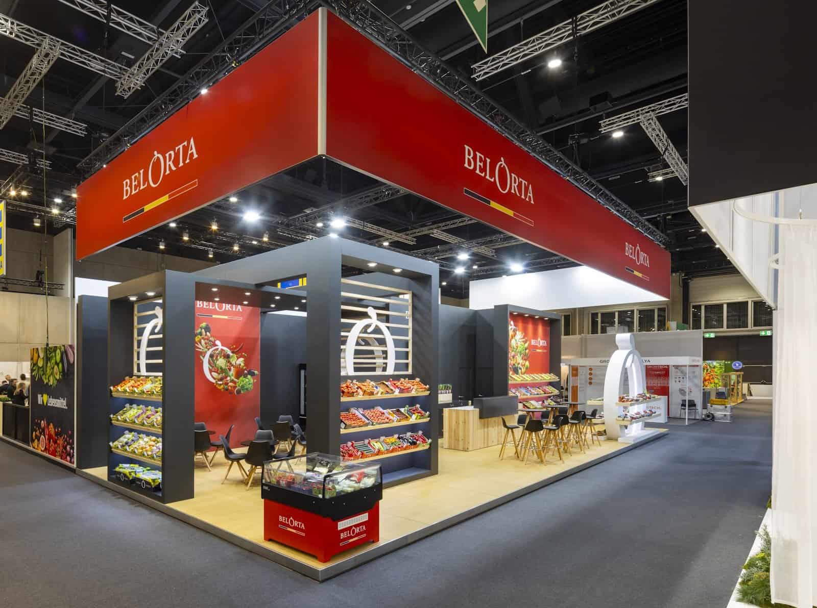 Grote Belorta stand met branded panelen, bedrukt met het logo en het typische rood van het merk.