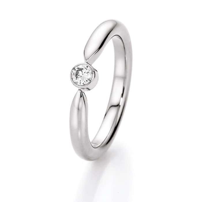 Weißgold Ring mit einem zentralen, runden Diamanten, der in einer geschwungenen Fassung gehalten wird.