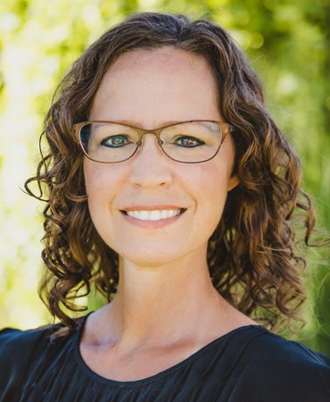 Headshot of a women with a black shirt brown hair standing outside | Dawn Jonas