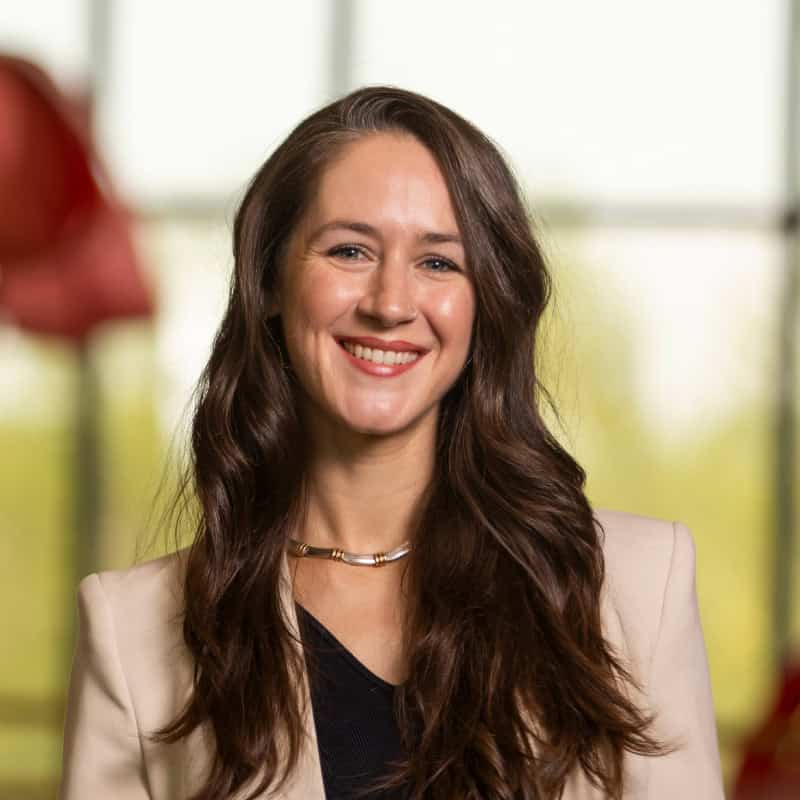 Headshot of a women in a light pink blazer | Sarah Trahan