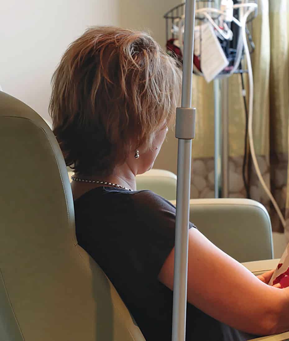 Women sitting in a medical chair reading a magazine