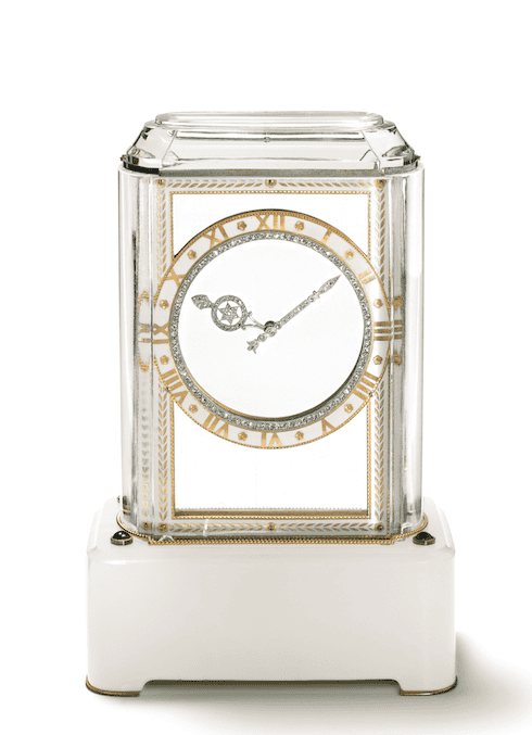 Mystery clock Model A, with a base of white agate and sapphire cabochons. The case is rock crystal with a beaded gold line at the bottom. The hour circle is gold with white enamel, Roman numerals and an inside line of platinum and rose-cut diamonds. The hands are platinum with rose-cut diamonds. Nick Welsh, Cartier Collection © Cartier