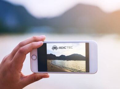 Mano sosteniendo un teléfono móvil mostrando una foto de un paisaje.