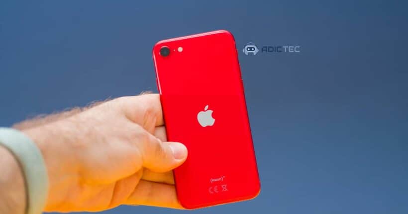 Mano sosteniendo un iPhone rojo por detrás.