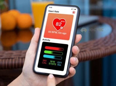 Una mano sostiene un teléfono inteligente mostrando una aplicación de salud con datos de frecuencia cardíaca, pasos y calorías quemadas.