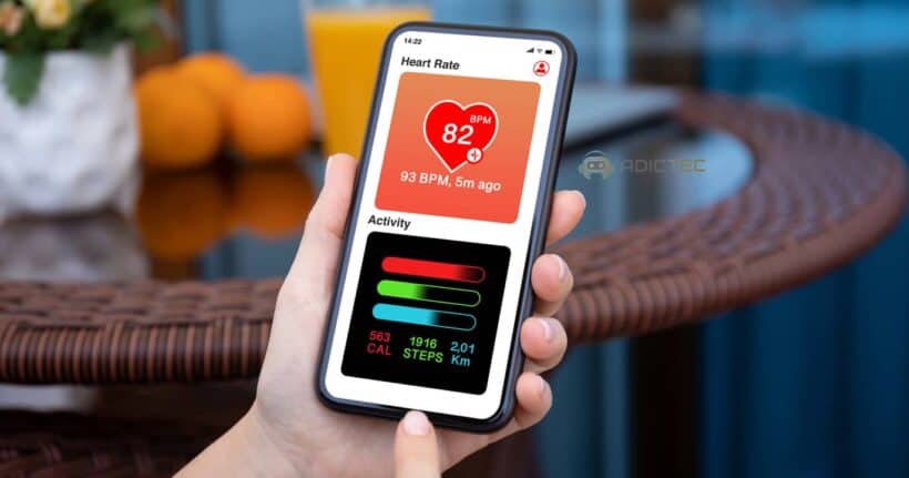 Una mano sostiene un teléfono inteligente mostrando una aplicación de salud con datos de frecuencia cardíaca, pasos y calorías quemadas.