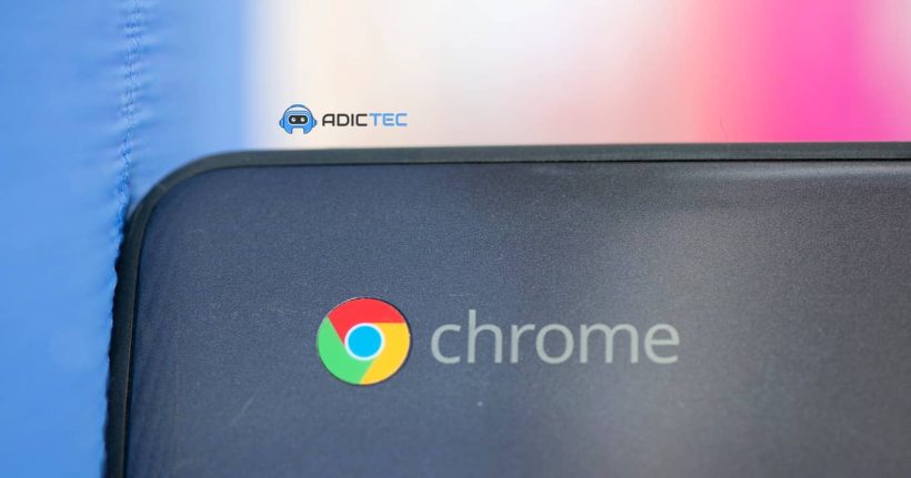 Primer plano del logotipo de Chrome en la tapa de un Chromebook gris oscuro. Un pequeño logotipo de "Adictec" aparece en la parte superior.