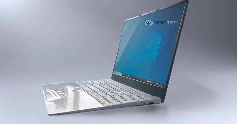 Imagen de un ultrabook plateado con pantalla mostrando el logo de Windows. El portátil se presenta con un diseño delgado y elegante, sobre un fondo neutro.
