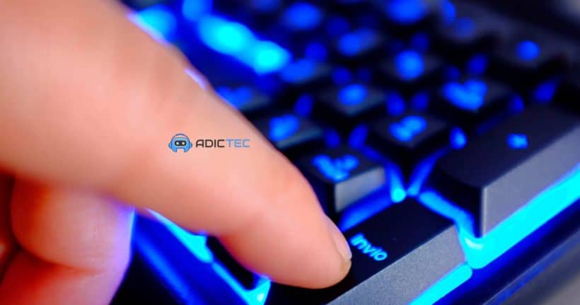 Un dedo presionando una tecla iluminada en un teclado, mostrando cómo apagar pc con el teclado.