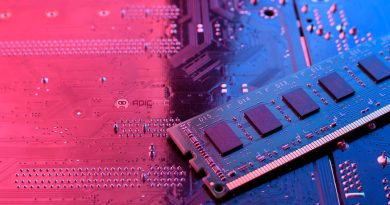 Un módulo de memoria RAM sobre una placa base de ordenador iluminada con luz rosa y azul.