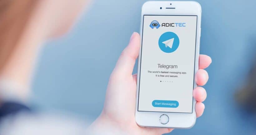 Mano sosteniendo un teléfono móvil con la aplicación Telegram abierta en la pantalla. Guía para recuperar chats borrados de Telegram.