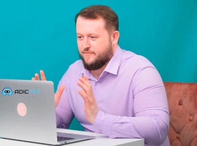 Hombre sentado frente a un portátil, explicando cómo solucionar un zumbido en un PC. Solución de problemas.