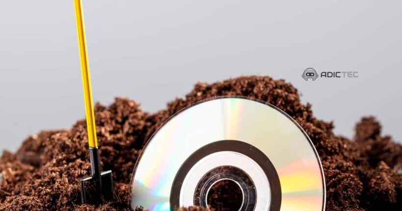 Un CD semienterrado en tierra, simbolizando la evolución del almacenamiento de datos y la obsolescencia tecnológica.