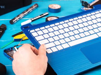 Técnico desmontando el teclado de una laptop azul para repotenciar sus componentes internos y mejorar su rendimiento.