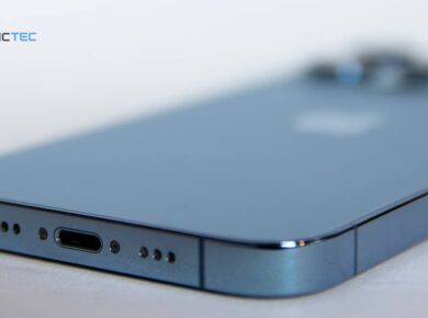 Rejillas del altavoz inferior de un iPhone azul junto al puerto de carga, la zona a limpiar del altavoz del iPhone