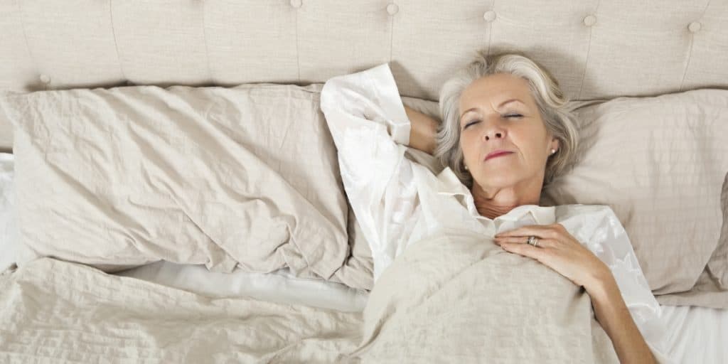 Senior woman, candidate for dentures, sleeping in bed.