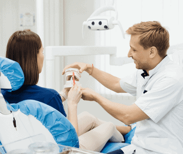 Dentist showing the correct dental hygiene on female patient.