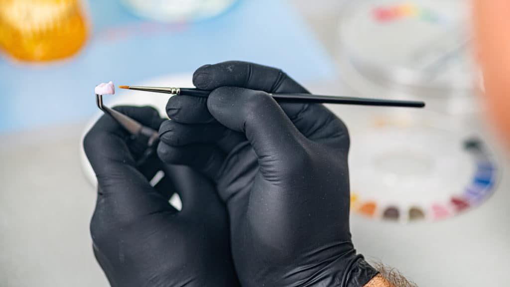 Dental technician fabricating a tooth crown.