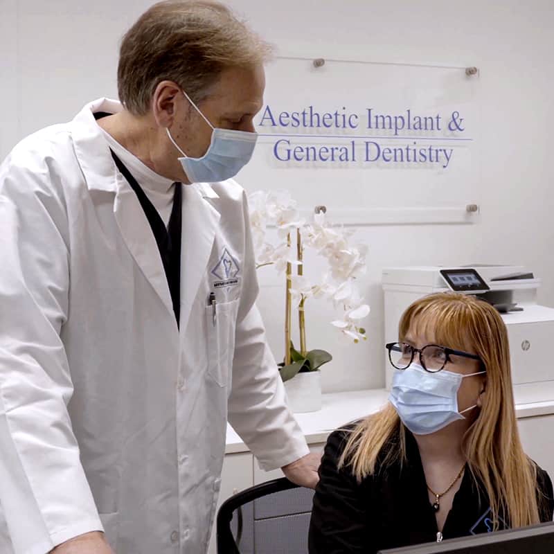 Dentist and receptionist on the front desk wearing face masks