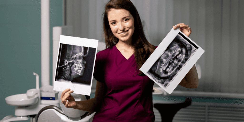 Dental professional holding two x-rays