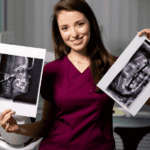 Dental professional holding two x-rays