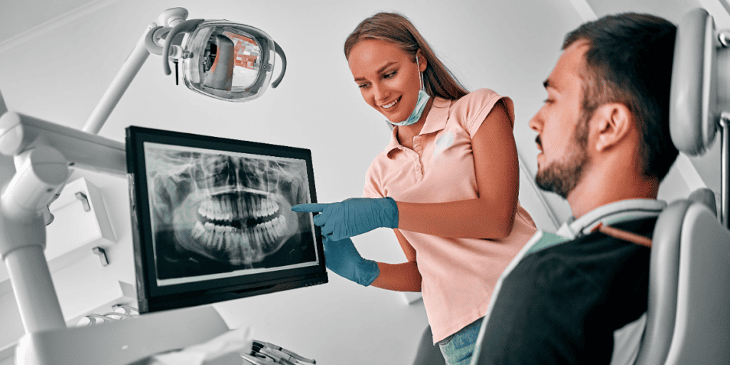 Dentist observing x-ray result with patient