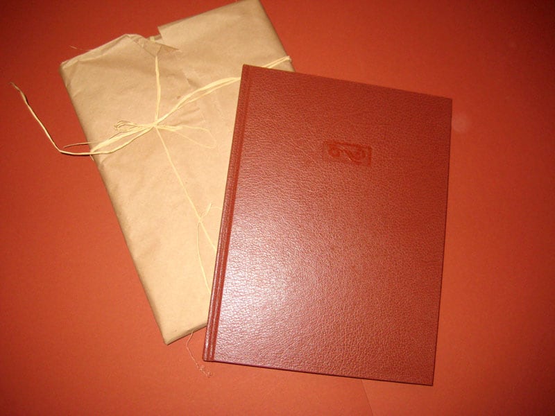 Custom travelog book, faux leather embossed cover and brown kraft paper packaging tied with string..