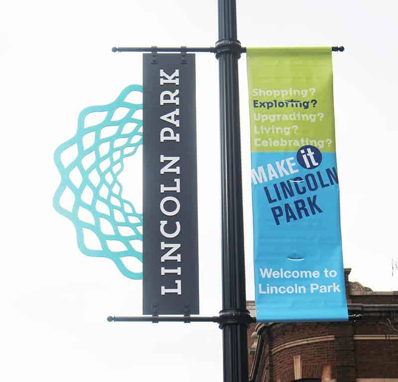 Street pole signage in Lincoln Park featuring the LPCC logo and a banner.
