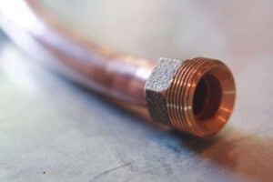 A close-up of a copper pipe with a threaded fitting, representing Bell Brothers’ commitment to quality plumbing service. Our trusted, background-checked technicians provide honest assessments with our exclusive No Surprise Guarantee—meaning upfront pricing and no hidden fees. Proudly serving Northern California communities, we’re dedicated to delivering reliable solutions you can trust.