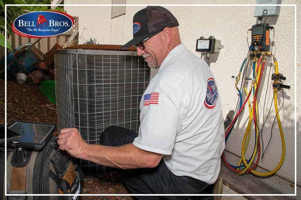 A Bell Brothers technician—background-checked and uniformed—carefully services an outdoor air conditioning unit with professional tools and diagnostic equipment. Our trusted team is known throughout Northern California for honest, upfront pricing and our No Surprise Guarantee, ensuring reliable service you can count on, every time.
