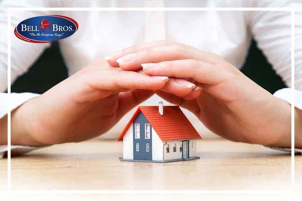 A caring pair of hands gently cups a small model house, symbolizing the trusted protection Bell Brothers provides to your home. The Bell Bros. logo appears in the top left corner, reflecting their strong reputation for reliable service across Northern California communities. Proudly featuring background-checked technicians, clear upfront pricing, and their No Surprise Guarantee, Bell Brothers ensures your comfort and peace of mind with every visit.