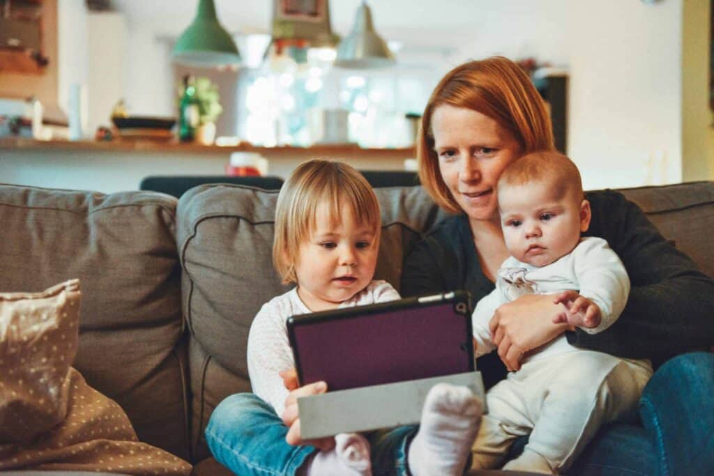 A smiling adult and two young children relax on a cozy couch, enjoying time together in a bright, welcoming living room. With Bell Brothers’ trusted service—including our No Surprise Guarantee, background-checked technicians, and honest upfront pricing—families across Northern California can feel confident their home comfort is in caring hands.