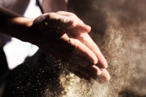 A close-up of hands clapping, releasing a burst of fine dust in the light—symbolizing Bell Brothers’ trusted, upfront approach to service. Our carefully background-checked technicians deliver expert care across Northern California communities, backed by our No Surprise Guarantee and clear pricing every time.