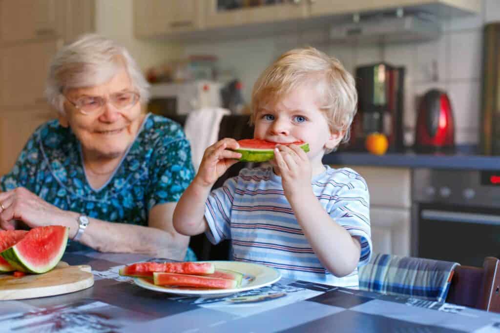 A young boy enjoys a slice of watermelon at the table beside his smiling grandmother. Just like this warm family moment, Bell Brothers provides trusted, dependable service to Northern California communities—with our No Surprise Guarantee ensuring upfront pricing, background-checked technicians you can welcome into your home, and a reputation built on honesty and care.