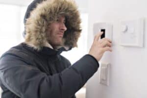 A Bell Brothers technician, professionally dressed and background-checked, helps a customer adjust their thermostat to stay cozy this winter. With our No Surprise Guarantee, transparent upfront pricing, and trusted service throughout Northern California communities, you can count on comfort without any unexpected surprises.