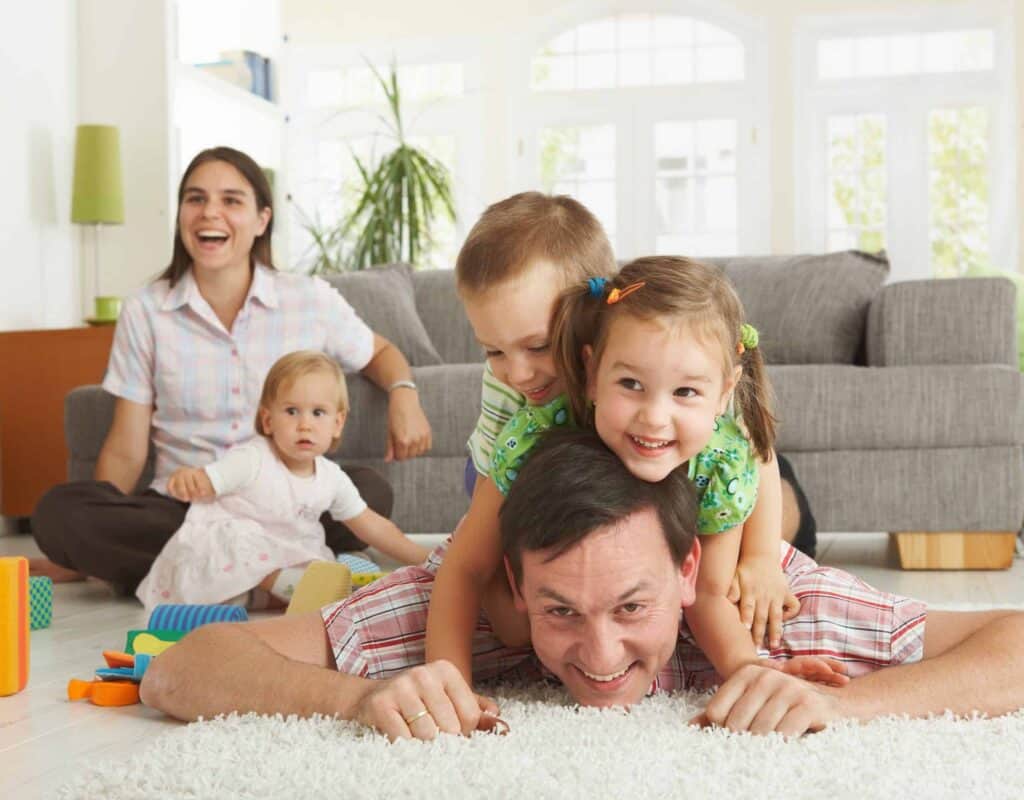 A happy family enjoys quality time together in their bright living room, confident in the comfort and safety provided by Bell Brothers. With our No Surprise Guarantee, background-checked technicians, and upfront pricing, families across Northern California trust us to keep their homes running smoothly—no surprises, just reliable service from a team with community roots.