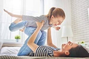 A parent and child, both happily smiling in matching striped shirts, enjoy playful time together in a sunlit room. Bell Brothers is dedicated to creating this comfort and peace of mind for families throughout Northern California, with our trusted No Surprise Guarantee, background-checked technicians, upfront pricing, and a strong reputation built on years of exceptional service in your community.